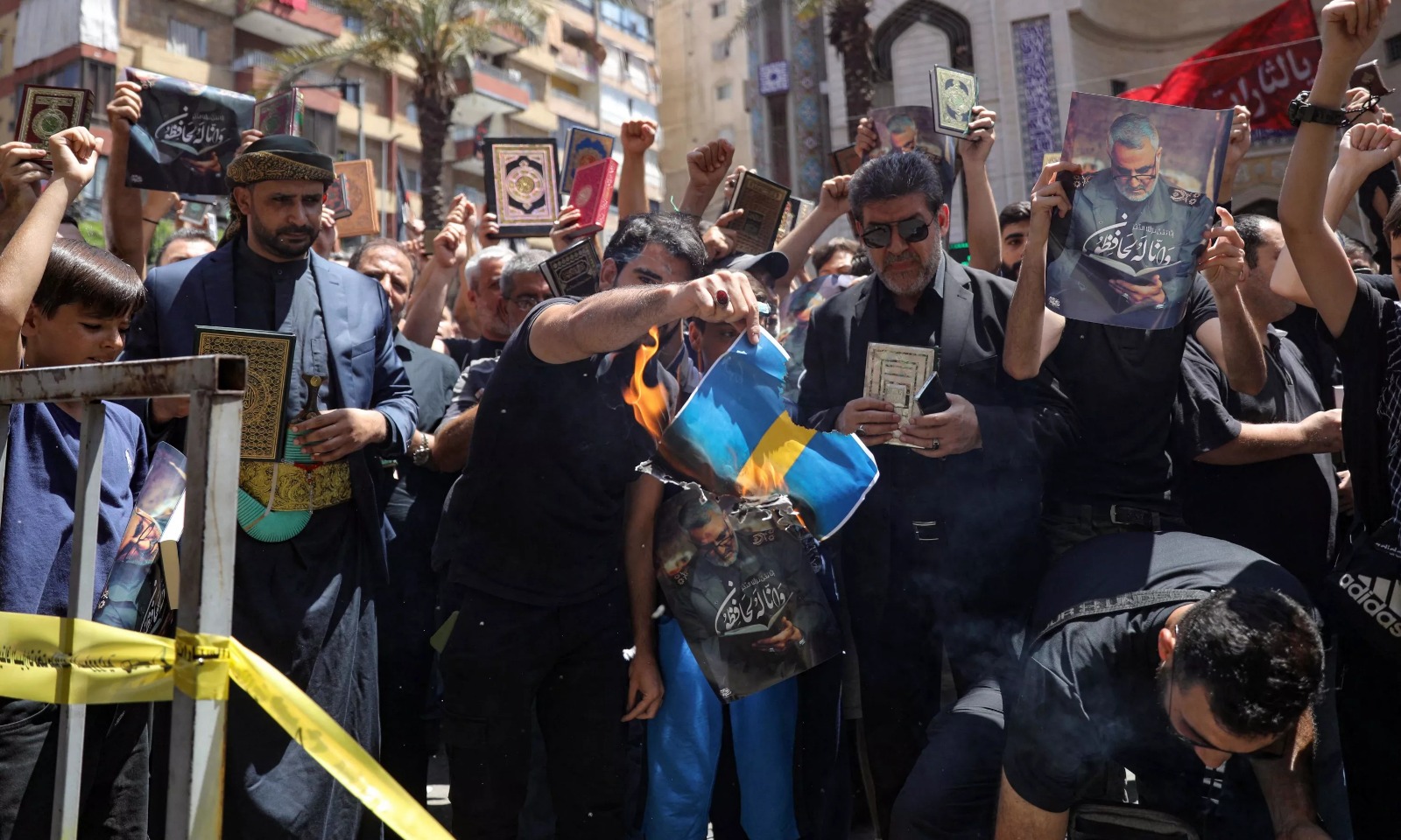 Un homme brûle un drapeau suédois lors d'une manifestation au Liban, le 21 juillet 2023. IBRAHIM AMRO / AFP