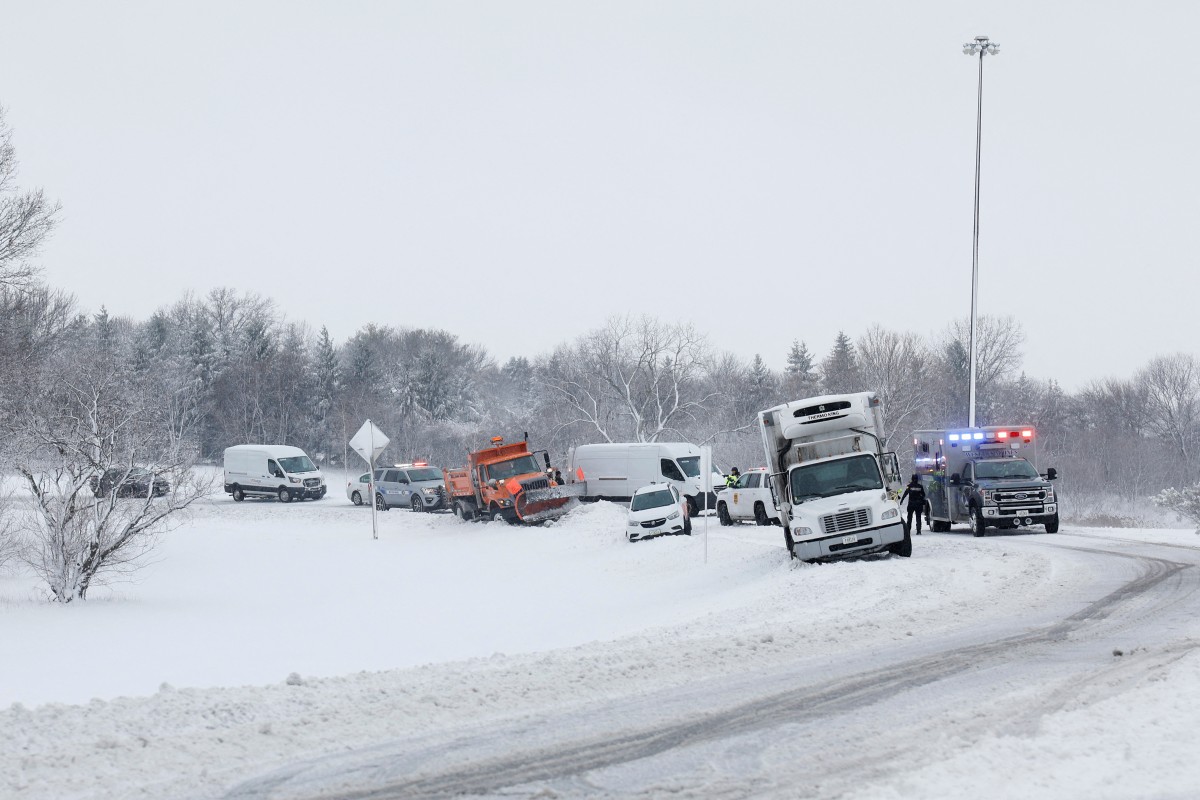 Les ambulanciers paramédicaux et les agents des forces de l'ordre s'efforcent de dégager une voiture bloquée sur une bretelle de sortie près d'une autoroute le 9 janvier 2024 à Des Moines, Iowa. Un système météorologique apporte les premières chutes de neige de l'hiver dans le centre de l'Iowa, alors que les électeurs se préparent pour les caucus présidentiels du Parti républicain de l'Iowa le 15 janvier.
