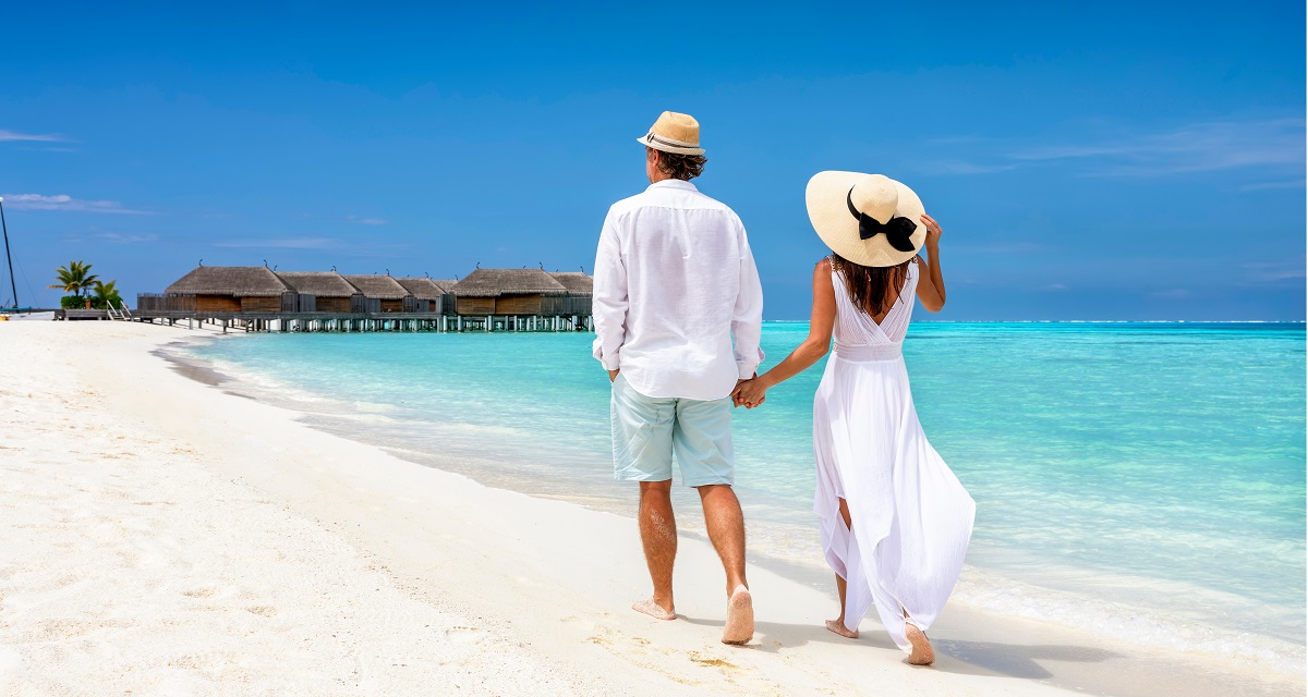 happy,couple,in,white,clothing,and,with,hats,walks,down