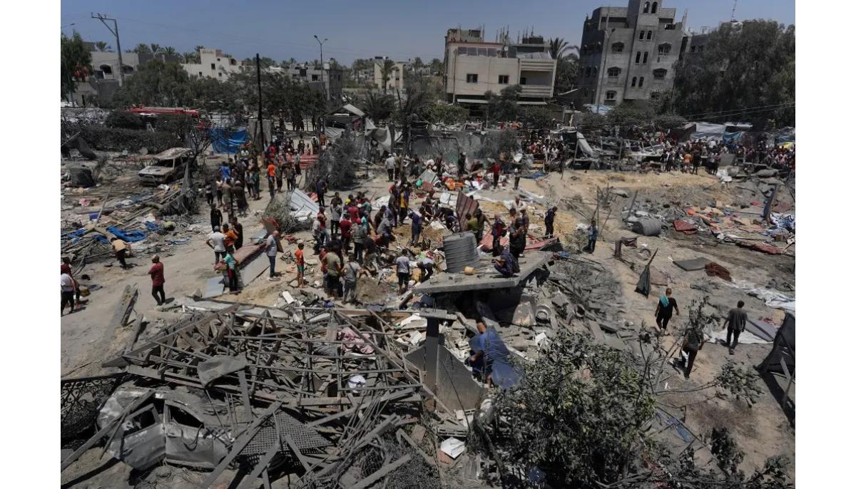 Des Palestiniens regardent les débris des tentes détruites et des structures d’habitation de fortune après une frappe militaire israélienne sur le camp de personnes déplacées d’al-Mawasi
