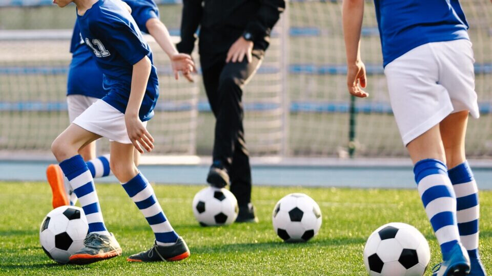 Des enfants jouant au football sur une pelouse