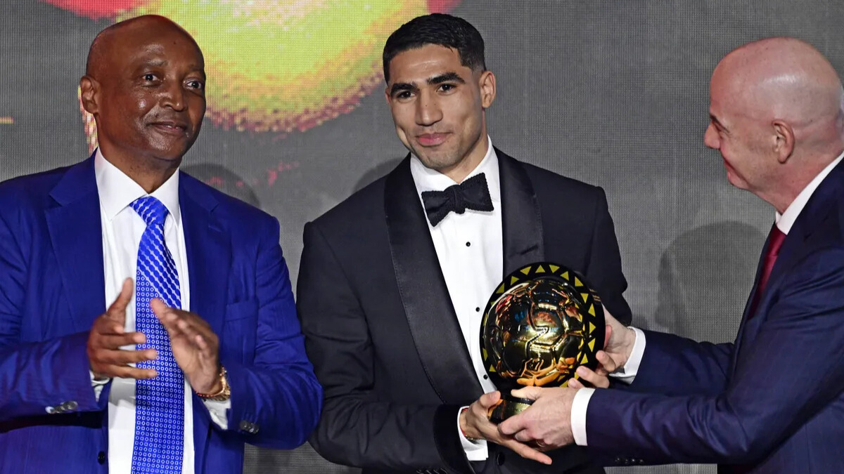 Achraf Hakimi en compagnie de Patrice Motsepe et Gianni Infantino lors des CAF Awards.